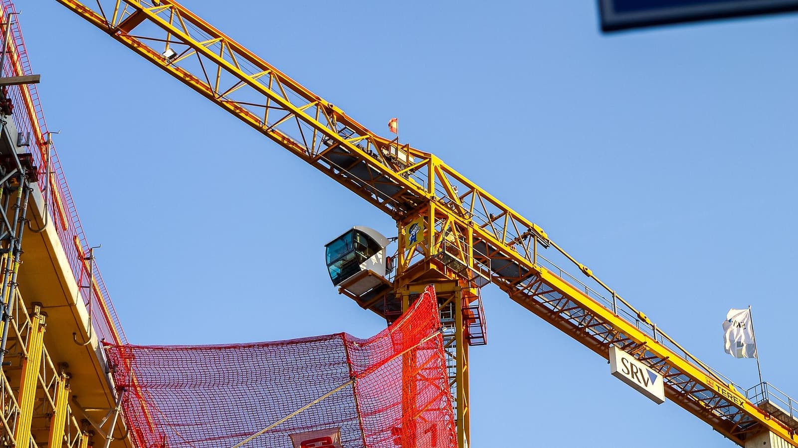 Lengan dan kabin tower crane kuning dilihat dari bawah